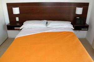 a large bed with a wooden headboard and a television at Altos de Maipu Rosario in Rosario