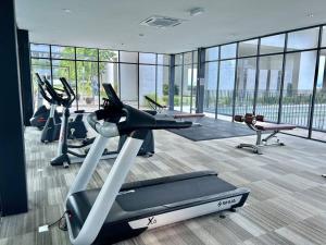 a gym with several cardio machines in a room at L 1-5Pax Cozy 3Bed Setia Alam Trefoil Wifi SmartTV in Setia Alam