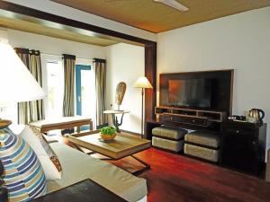 a living room with a couch and a flat screen tv at Suite Lanka in Hikkaduwa