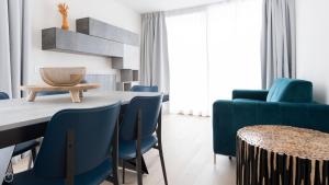 a dining room with blue chairs and a table at Italianway - Dosso del Grillo 1A in Valdidentro
