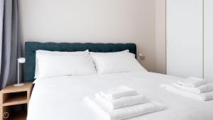 a bedroom with a white bed with towels on it at Dosso del Grillo 1A in Valdidentro +58 photos