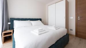 un letto bianco con due asciugamani sopra di Italianway - Dosso del Grillo 1A a Valdidentro