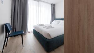 a bedroom with a bed and a chair next to a window at Dosso del Grillo 1A in Valdidentro