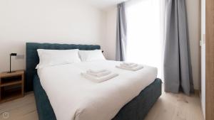 a bedroom with a bed with two towels on it at Dosso del Grillo 1A in Valdidentro