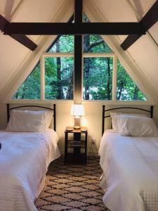 sypialnia na poddaszu z 2 łóżkami i oknem w obiekcie Newly renovated A-frame 5 Min walk to main street w mieście Highlands