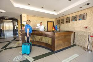 a person with a suitcase waiting at a reception desk at selin otel spa belek in Belek