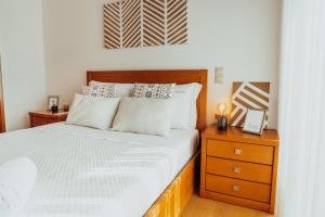 um quarto com uma cama e uma mesa de cabeceira em madeira em RACIA Lodges - Apartment em Viana do Castelo