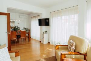 a living room with a couch and a dining room at RACIA Lodges - Apartment in Viana do Castelo