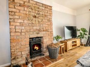una chimenea de ladrillo con un reloj en la pared en Hunters Lodge, with parking for one car, en Lincoln
