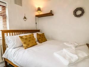 a bedroom with a white bed with yellow pillows at Hunters Lodge, with parking for one car in Lincoln