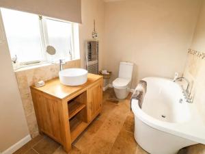 a bathroom with a tub and a sink and a toilet at Hunters Lodge, with parking for one car in Lincoln