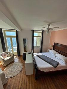 Schlafzimmer mit einem Bett, einem Stuhl und Fenstern in der Unterkunft Albergo Gargnano in Gargnano
