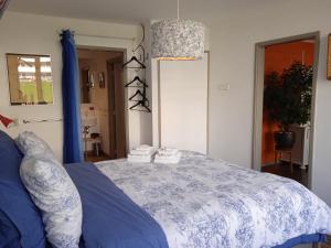 Schlafzimmer mit einem Bett mit blauer und weißer Bettwäsche in der Unterkunft Bed and Breakfast Amsterdam West in Amsterdam