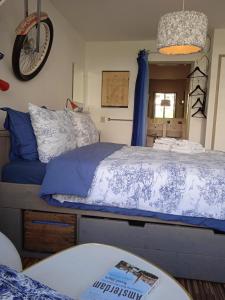 1 dormitorio con 1 cama con sábanas azules y blancas en Bed and Breakfast Amsterdam West, en Ámsterdam