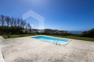 a swimming pool in the middle of a tiled yard at Blue Beach by ACasaDasCasas in Ericeira