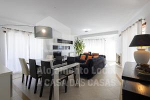 een woonkamer en eetkamer met een tafel en een bank bij Blue Beach by ACasaDasCasas in Ericeira