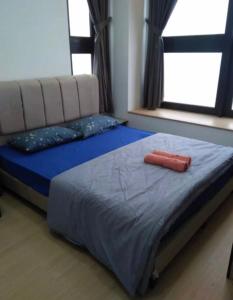 a bed with a red object on it in a bedroom at Sunway Grid by One Team in Kampong Pendas