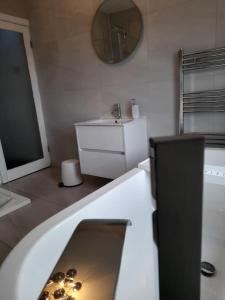 uma casa de banho com uma banheira, um lavatório e um espelho. em Fabulous terrace cottage em Blackpool
