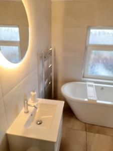 La salle de bains est pourvue d'un lavabo, d'une baignoire et d'un miroir. dans l'établissement Fabulous terrace cottage, à Blackpool