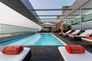 ein Schwimmbad mit Liegestühlen neben einem Gebäude in der Unterkunft Hotel Baia in Luanda
