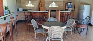 Pousada Villa D' Garden في ريبيراو بريتو: مطعم بطاولة وكراسي ومطبخ