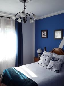 um quarto azul com uma cama e uma parede azul em Casa Rural Mariluz em Santillana del Mar