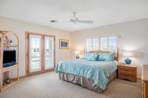 a bedroom with a bed and a flat screen tv at The Nautical Nimbus in Big Pine Key
