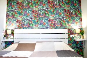 - une chambre avec un lit et un papier peint floral dans l'établissement Viareggio Deluxe, à Viareggio