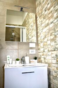 La salle de bains est pourvue d'un lavabo blanc et d'un miroir. dans l'établissement Viareggio Deluxe, à Viareggio