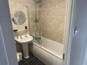 a bathroom with a sink and a toilet and a tub and a mirror at River View House St Neots - Navigation Wharf in Saint Neots