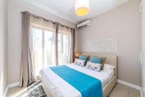 Un dormitorio con una cama y una ventana grande. en Beachcove No 6, en Grand Baie