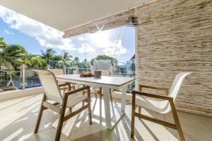 a dining room with a white table and chairs at Beachcove No 6 in Grand Baie