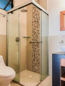 a glass shower in a bathroom with a toilet at Casa Amarilla in Guanajuato