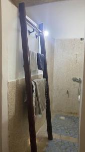 uma casa de banho com chuveiro e toalhas na parede em Petite maison en bord de mer em Palmarin Nguèdj