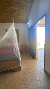 una habitación con una cama con una bolsa de plástico. en Petite maison en bord de mer en Palmarin Nguèdj