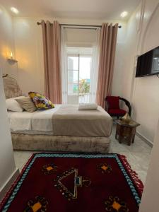 a bedroom with a bed with a window and a rug at Hotel Palace tanger in Tangier