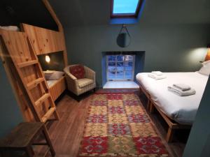Habitación con 2 camas, silla y alfombra. en Comrie Croft en Crieff