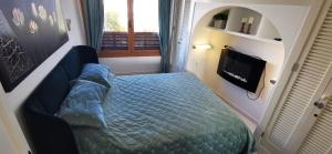 a small bedroom with a blue bed and a window at Apartment AlcudiaMar in Alcudia