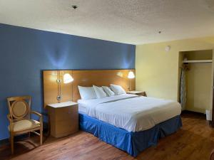 a hotel room with a bed and a chair at Motel 6 Savannah, GA - Gateway & I-95 in Savannah