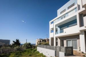 a white house with the ocean in the background at Euphoria Blue Villa στην περιοχή Ιξιά in Rhodes Town