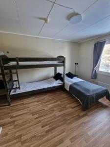 two bunk beds in a room with a wooden floor at Badeland Gjestegård in Raufoss