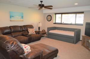 a living room with a couch and a bed at Bridges Bay Vacation Cabin 185 in Arnolds Park