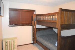 a bedroom with two bunk beds and a window at Bridges Bay Vacation Cabin 185 in Arnolds Park