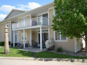 a yellow house with a porch and a deck at 84 Rohr 7B in Arnolds Park