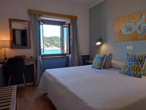 ein Hotelzimmer mit einem Bett und einem Fenster in der Unterkunft Hotel Cap d'Or in Tossa de Mar