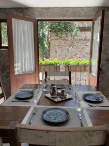 a wooden table with plates and wine glasses on it at Hermoso departamento en Val’Quirico Loft Frontana in Tlaxcala de Xicohténcatl