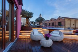 una terraza de madera con 2 sillas y una mesa en Palazzo Ferrucci Luxury Suites en Cagliari