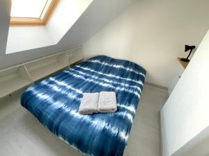 モレ・シュル・ロワンにあるEscapade Morétaine - Le Loftのベッド1台(タオル2枚付)が備わる客室です。