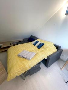 a bedroom with a bed with a yellow blanket at Loft renové avec Mezzanine - Vue sur le Loing - Commerces à pied in Moret-sur-Loing +10 photos