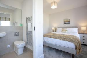 um quarto com uma cama, um WC e um lavatório em Wish You Were Here, Crantock em Newquay